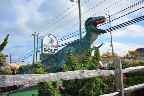 A dinosaur statue in front of a golf course sign. - Traditional, spacious 1 bedroom oceanfront condo with free WiFi, suede furniture, and an amazing view of the ocean located in exciting downtown only steps to beach and a few streets to boardwalk! (Ocean City)