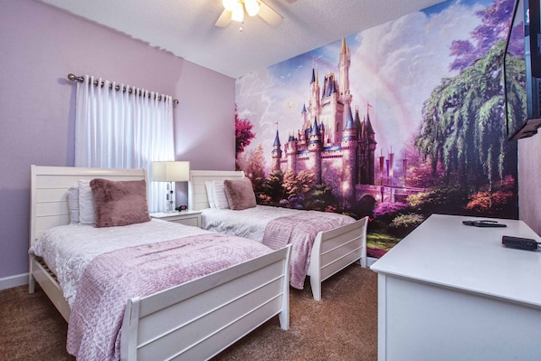 Une chambre avec deux lits, un bureau et une grande fresque représentant un château sur le mur.