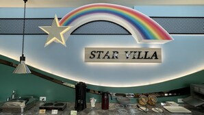 Bancada de recepção com uma placa indicando "STAR VILLA" e um lustre em formato de estrela acima.