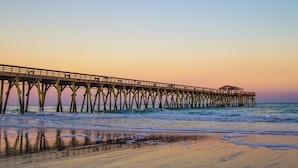 A pier extending into the ocean with a small structure at the end. - Boardwalk Resort by Hosteeva (Myrtle Beach)