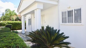 A white building with a covered porch, a door labeled '6', and a window with shutters. - Villa, sea views, FREE A/C, pool, roof terrace, Wifi (Peyia)