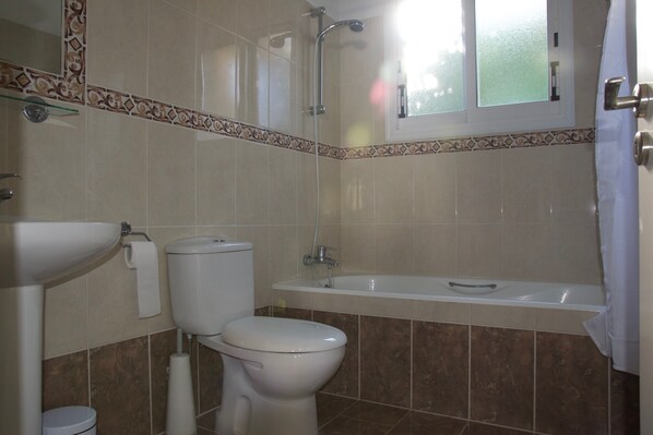 Un baño con inodoro, lavamanos y bañera.