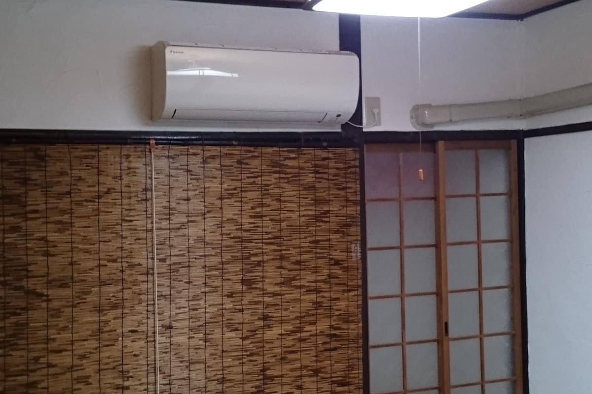 A traditional Japanese room with tatami flooring, a shoji screen, and a sliding door.