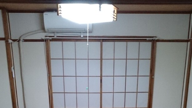 A traditional Japanese room with tatami mats, a futon bed, and a shoji screen. - Abiko Guest House (Osaka)