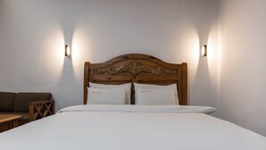 A neatly made bed with a wooden headboard, two pillows, and two wall-mounted light fixtures. - Suanbo Hotel Screen (Chungju)
