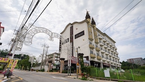 A multi-story hotel with a prominent entrance, balconies, and a sign indicating the name 'Porteen'. - Suanbo Hotel Screen (Chungju)