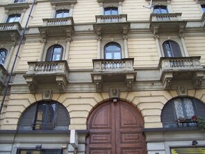 Stately building with a central entrance, arched windows, and ornate details.