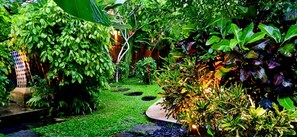 A lush garden with various plants and a small water feature. - Baliwid Villa Ubud (Sukawati)