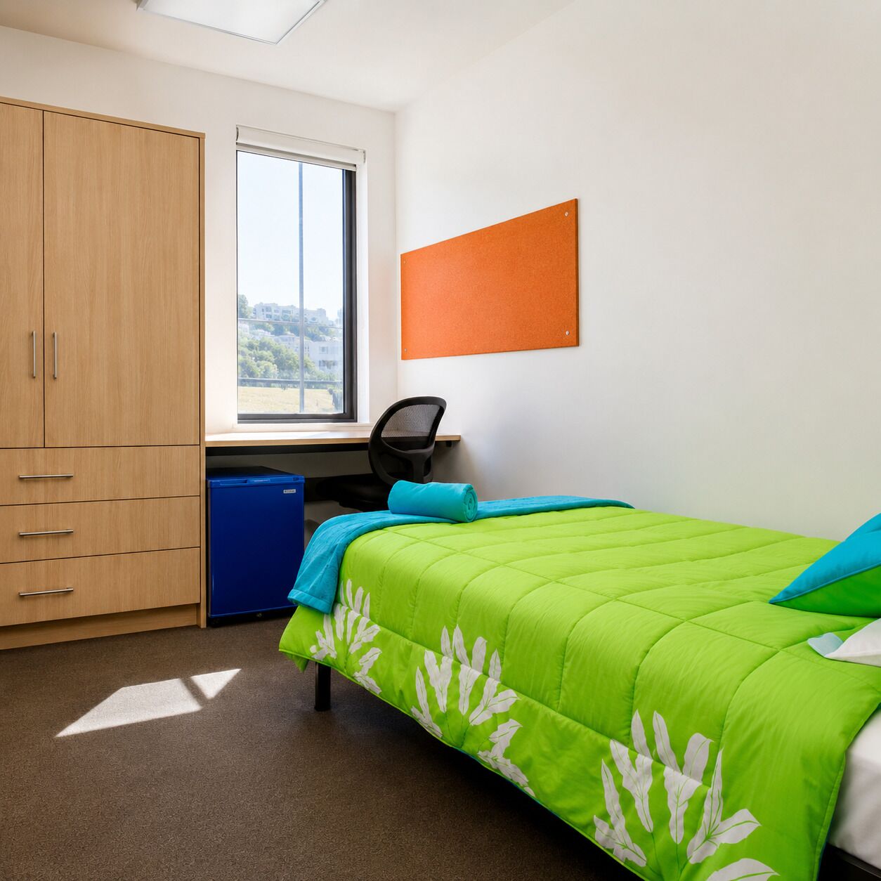 Une chambre à coucher avec un lit, un bureau, une chaise, une armoire et une fenêtre.