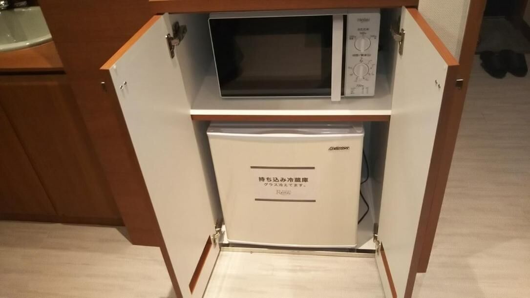 A compact kitchen with a microwave and a refrigerator.