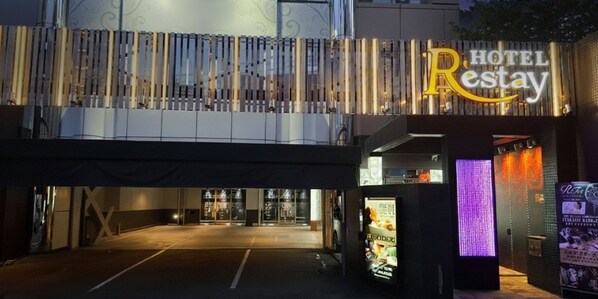 A hotel entrance with a sign reading "HOTEL Restay" and a modern design with vertical light fixtures. - Restay Hiroshima - Adult Only (Hiroshima)