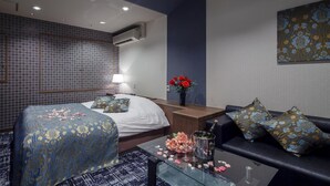 A hotel room with a bed, a sofa, a coffee table, and a desk. - Restay Hiroshima - Adult Only (Hiroshima)