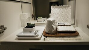A clean, modern bathroom with a white countertop, a sink, a mirror, and a shower area. - Restay Hiroshima - Adult Only (Hiroshima)
