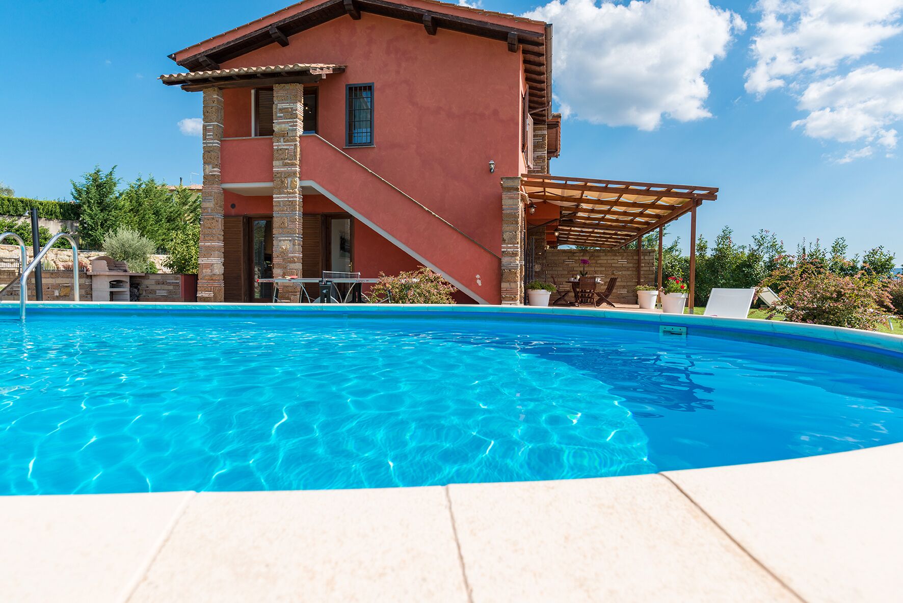 Une piscine avec une maison en arrière-plan.