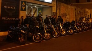 Una fila de motocicletas estacionadas frente a un restaurante llamado 'Picanhas'.