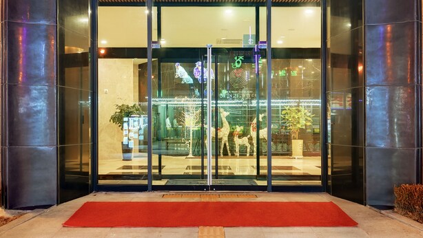 The entrance to the Sea & Moon Tourist Hotel with a modern design, featuring a prominent logo above the entrance and a red carpet leading inside. - Sea & Moon Tourist Hotel (Incheon)