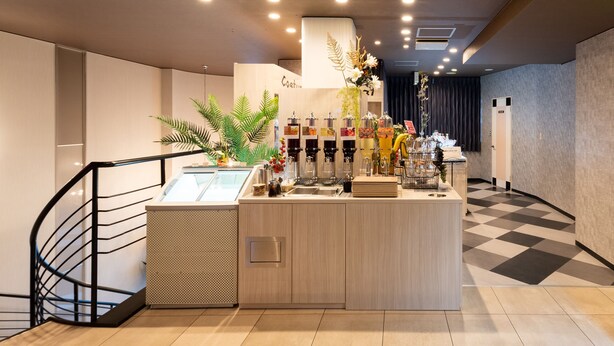 Un área de bar moderna con suelo a cuadros, mostrador de madera y varios dispensadores de bebidas.