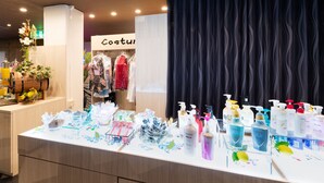 Un mostrador de venta al público con diversos productos de cuidado personal y una sección de ropa al fondo.