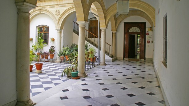 A spacious courtyard with a checkered floor, arches, and potted plants. - Luxury, light & spacious loft-apartment  great for longer stays, private parking (Jerez)