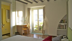 A bedroom with a bed, a desk, a chair, a bookshelf, and a sliding glass door to a balcony. - Luxury, light & spacious loft-apartment  great for longer stays, private parking (Jerez)
