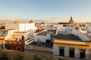 Una zona urbana densamente poblada con edificios blancos, algunos con techos planos y otros con techos inclinados. Se observan balcones y terrazas, y una torre destacada con un reloj.