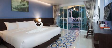 Habitación de hotel con una cama grande, un escritorio y vistas al exterior.