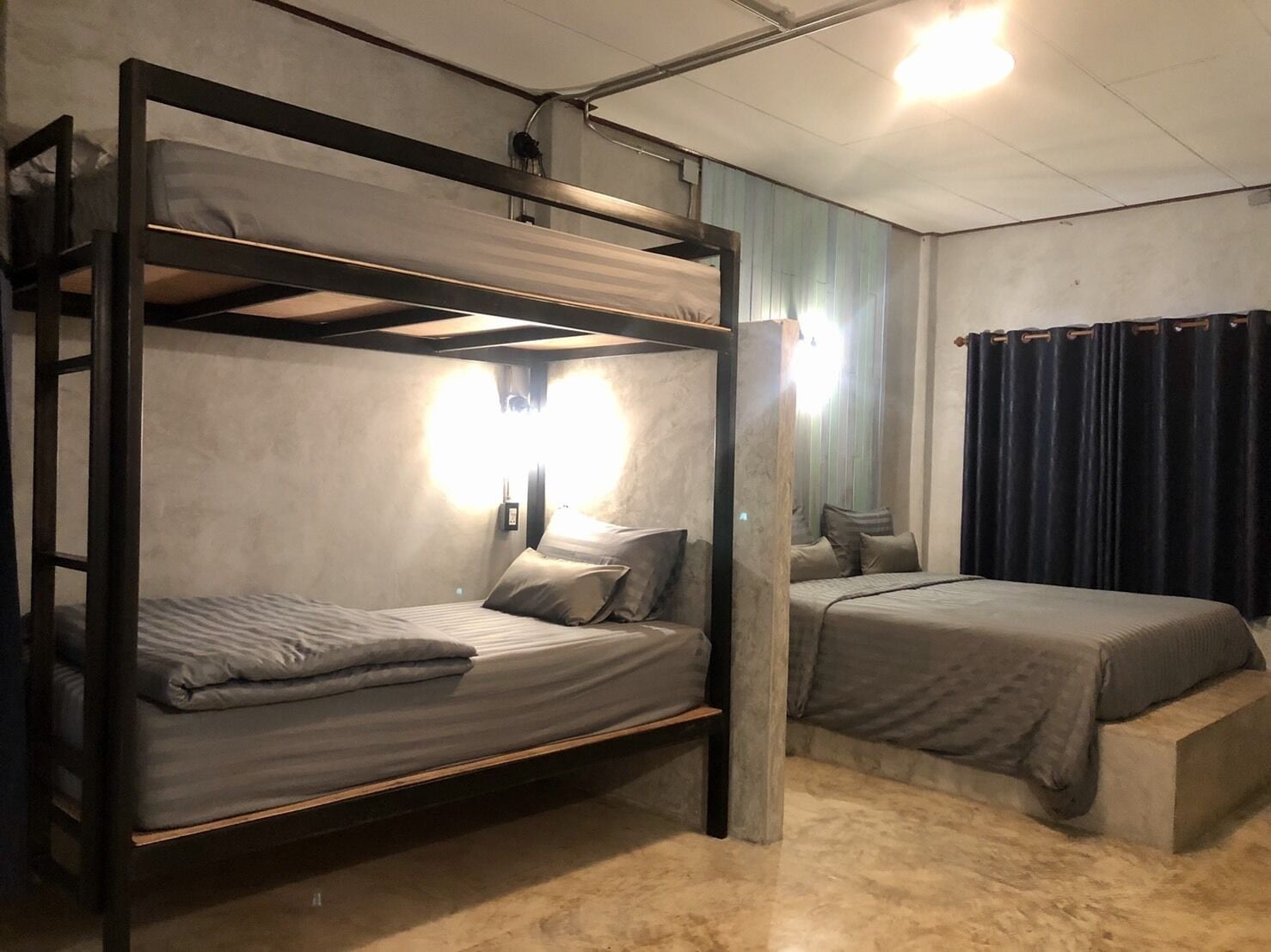 A bunk bed room with a ladder, a bedside table, and a nightstand.