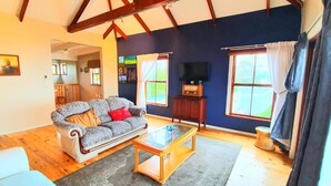 A living room with a sofa, coffee table, and a TV. - Happy Home Imhoffs Gift (Cape Town)