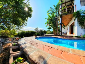 Een buitenzwembad en ligstoelen