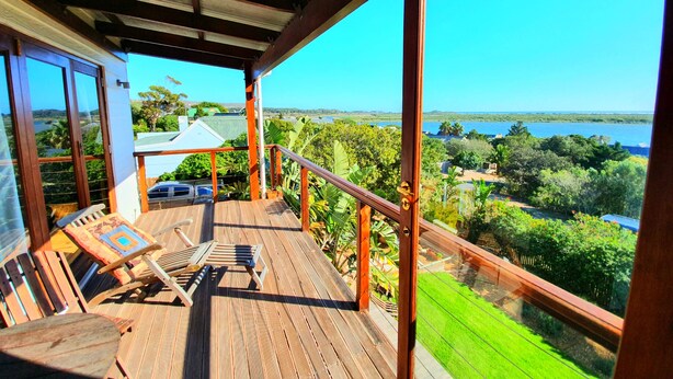 A wooden deck with a view of a lake and greenery. - Happy Home Imhoffs Gift (Cape Town)