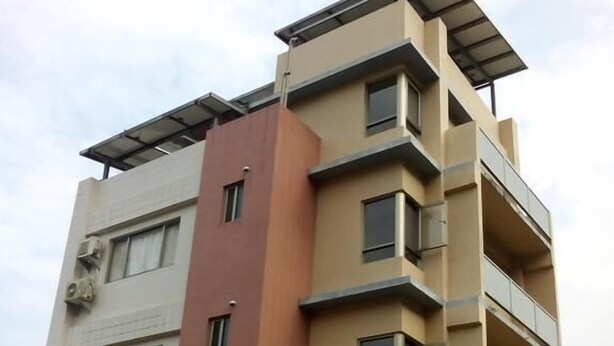 A multi-story residential building with balconies and solar panels on the roof. - Skywater (Puli)