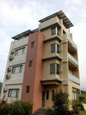 A multi-story residential building with balconies and solar panels on the roof. - Skywater (Puli)