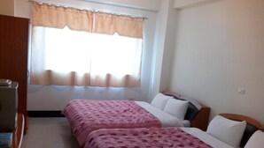 A room with two beds, a wooden wardrobe, a window with a beige curtain, and a tiled floor. - Skywater (Puli)