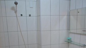 A small bathroom with a toilet, sink, and shower. - Skywater (Puli)