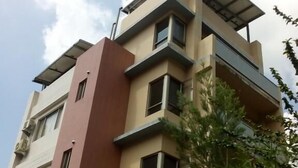 A multi-story building with a flat roof, large windows, and balconies. - Skywater (Puli)