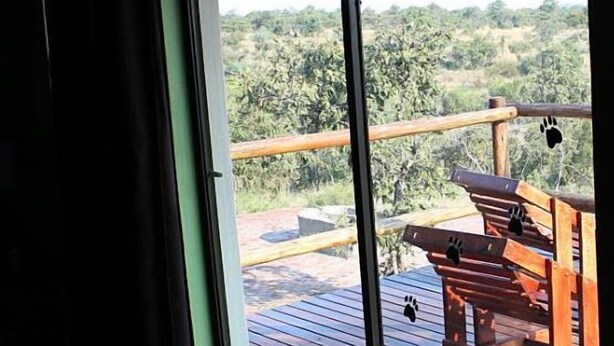 A room with a large sliding glass door leading to an outdoor deck with a wooden railing and a bench. - 24 Bush House (Bela-Bela)