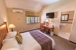 A bedroom with a bed, a desk, a chair, a television, and a bathroom. - Constantia Hotel and Conference Centre (Midrand)