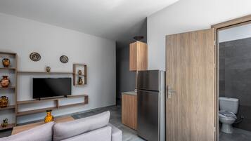 Una cocina moderna con horno empotrado, refrigerador y un mueble de madera.