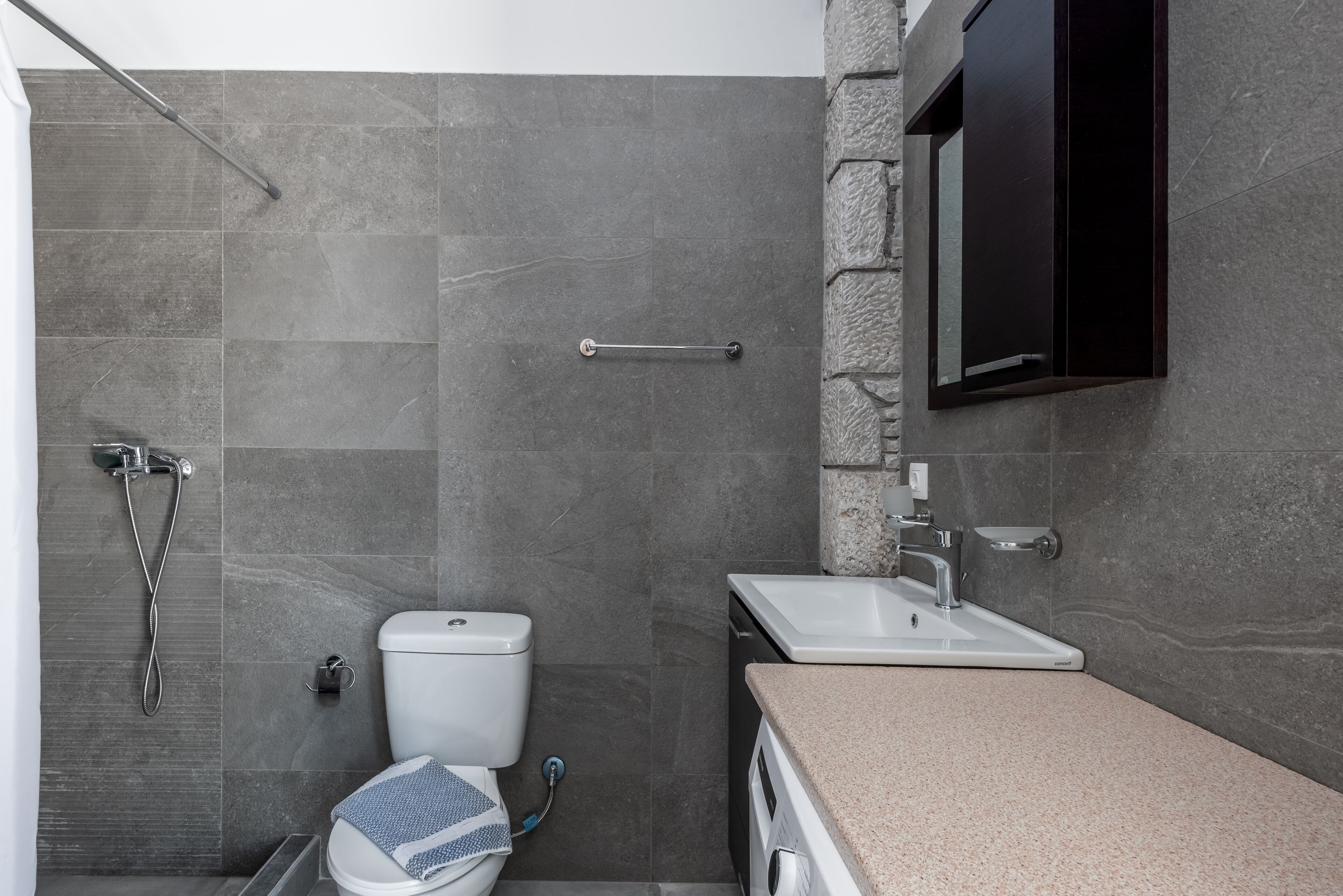 Un baño moderno con inodoro, ducha y lavabo.