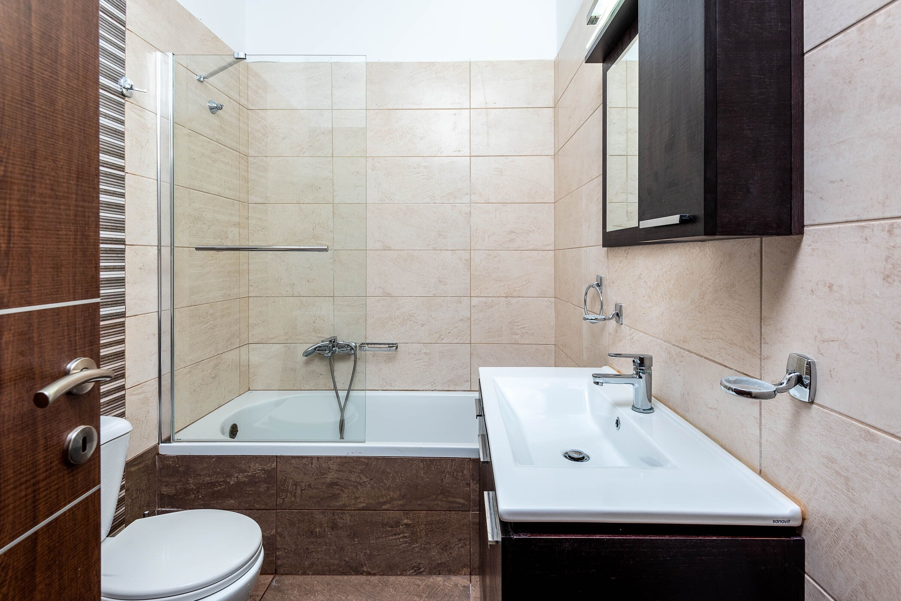 A bathroom with a toilet, a bathtub, and a sink.