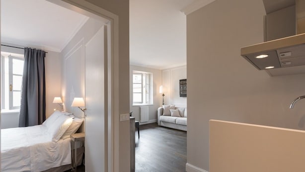 Une chambre d’hôtel moderne équipée d’un lit, d’une table de chevet, d’une lampe et offrant une vue sur l’espace de vie.