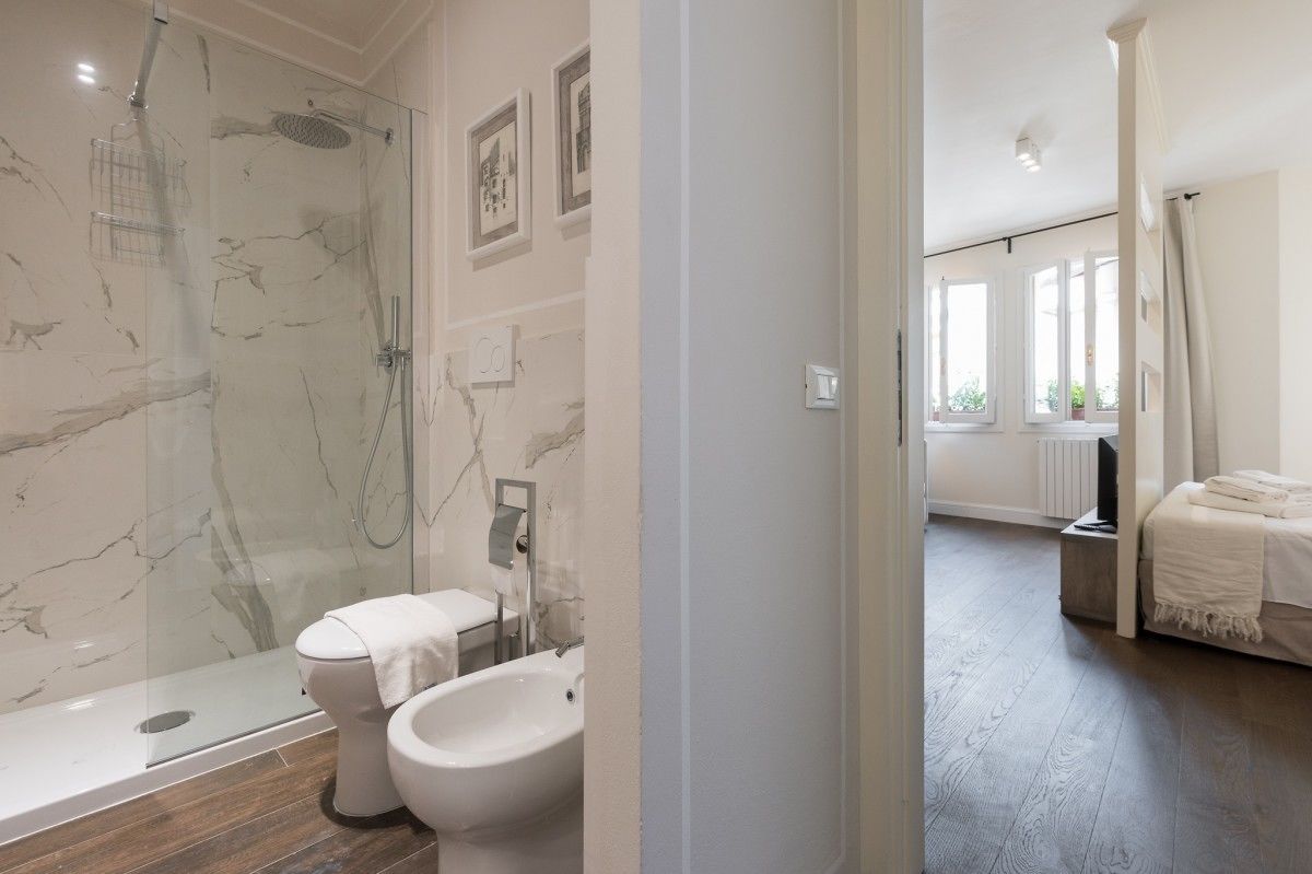 Une salle de bain moderne avec une douche à parois de verre, des toilettes et un lavabo.