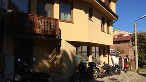 A two-story building with a balcony and several motorcycles parked in front. - Root Hotel Old Town (Plovdiv)