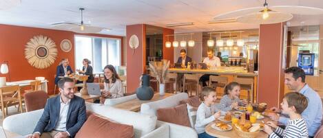 A modern dining area with sofas, tables, and a bar.