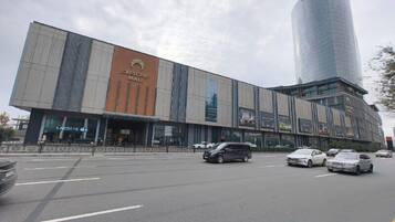 Um shopping moderno com uma placa em forma de crescente e um edifício cilíndrico alto.