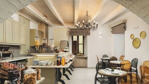 A modern kitchen with a dining area, featuring a central island, wooden cabinets, and a chandelier. - Elia Palazzo Hotel (Chania)