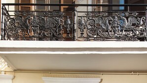 A hotel entrance with a white door, a staircase, and a balcony with ornate metal railings. - Elia Palazzo Hotel (Chania)