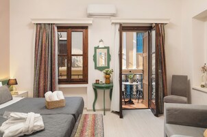 Quarto de hotel com duas camas, uma mesinha com um vaso e vista para a varanda.