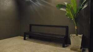 A dark room with a bench and a potted plant. - Capsule Hostel Chiangkhan (Chiang Khan)