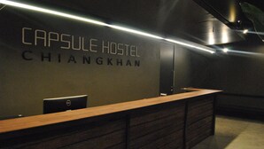 A Capsule Hostel Chiang Khan reception desk with a Dell computer and a wooden counter. - Capsule Hostel Chiangkhan (Chiang Khan)